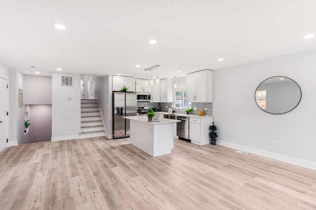 337 W 106th Pl, Chicago, IL 60628 - kitchen featuring appliances with stainless steel finishes, a kitchen island, light countertops, tasteful backsplash, and light wood-type flooring