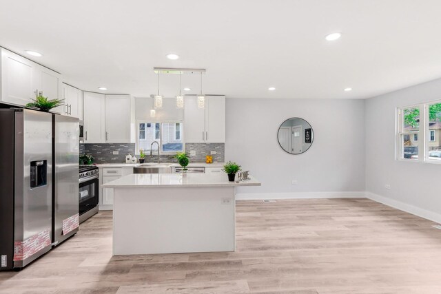 337 W 106th Pl, Chicago, IL 60628 - kitchen featuring appliances with stainless steel finishes, baseboards, light countertops, white cabinetry, and a kitchen island