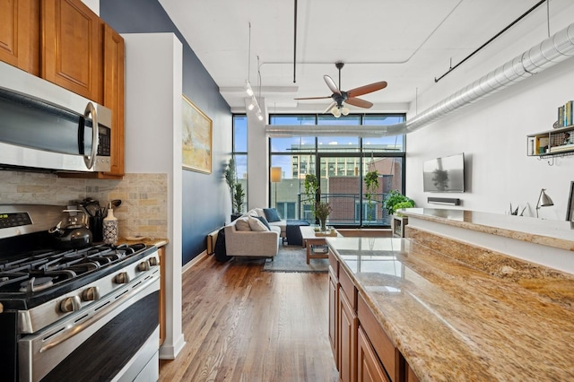 1224 W Van Buren Ave Unit 416, Chicago, IL 60607 - kitchen featuring stainless steel appliances, brown cabinets, tasteful backsplash, ceiling fan, and wood finished floors