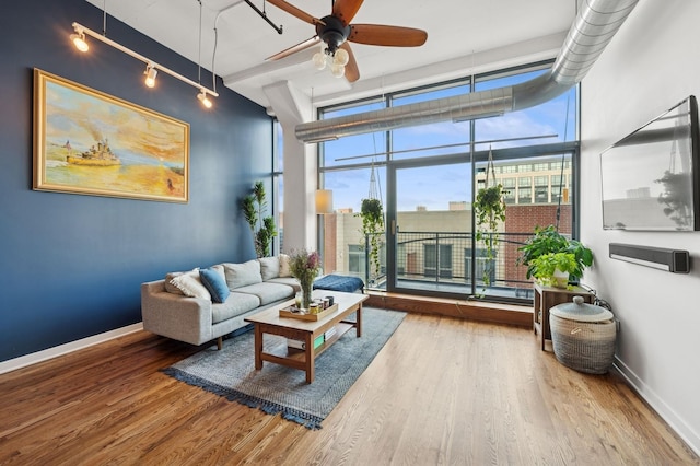 1224 W Van Buren Ave Unit 416, Chicago, IL 60607 - living room featuring wood finished floors, ceiling fan, baseboards, track lighting, and expansive windows