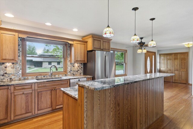 717 S Kennedy St, Shannon, IL 61078 - kitchen featuring appliances with stainless steel finishes, a sink, a kitchen island, a ceiling fan, and decorative backsplash