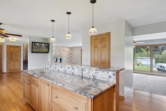 717 S Kennedy St, Shannon, IL 61078 - kitchen with ceiling fan, light wood-type flooring, light stone counters, and a large fireplace