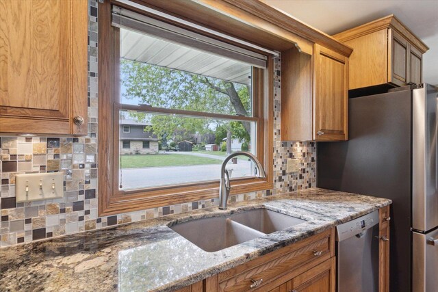 717 S Kennedy St, Shannon, IL 61078 - kitchen featuring appliances with stainless steel finishes, a sink, decorative backsplash, brown cabinets, and light stone counters