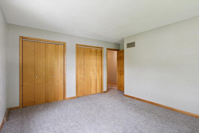 717 S Kennedy St, Shannon, IL 61078 - unfurnished bedroom featuring two closets, carpet flooring, and baseboards