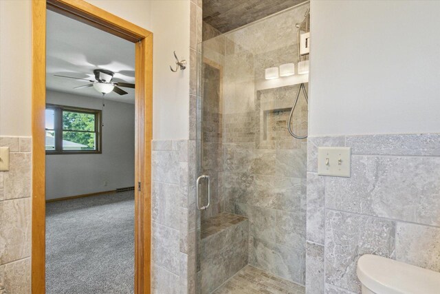 717 S Kennedy St, Shannon, IL 61078 - full bathroom with tile walls, a shower stall, a ceiling fan, toilet, and wainscoting