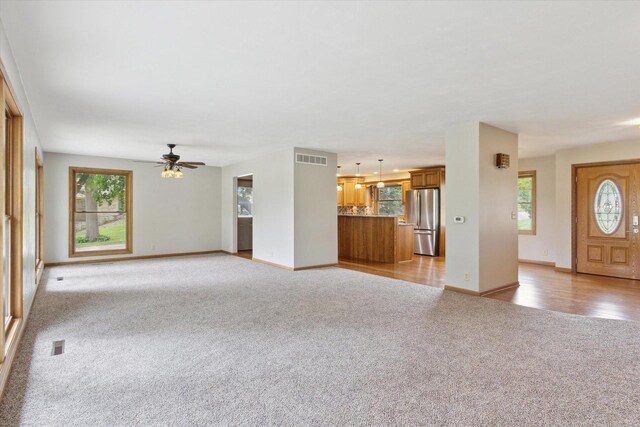 717 S Kennedy St, Shannon, IL 61078 - unfurnished living room with light colored carpet, a ceiling fan, baseboards, and healthy amount of natural light
