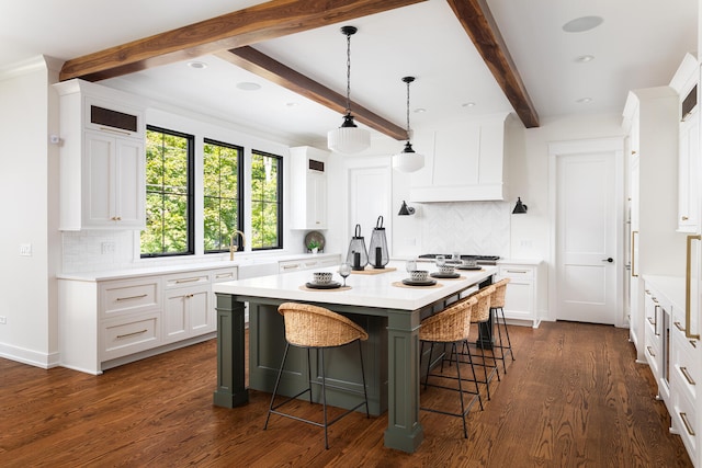 706 S Loomis St, Naperville, IL 60540 - kitchen with light countertops, backsplash, a breakfast bar area, white cabinetry, and beamed ceiling