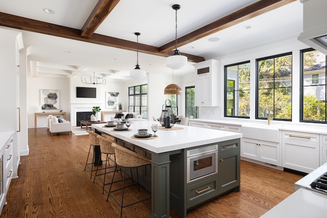 706 S Loomis St, Naperville, IL 60540 - kitchen featuring a sink, white cabinets, beam ceiling, light countertops, and a breakfast bar
