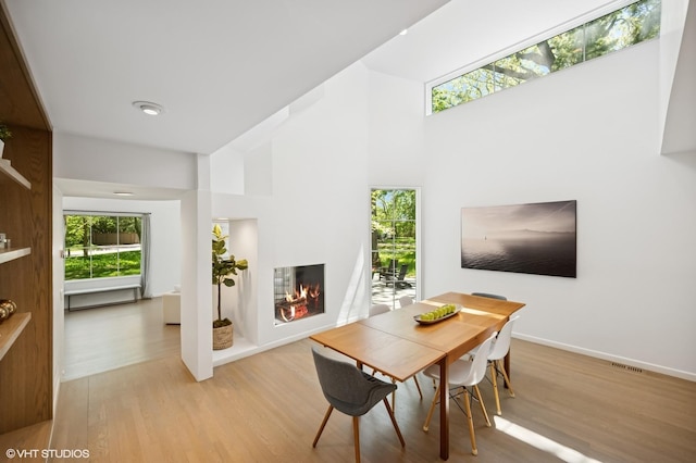 938 Old Green Bay Rd, Winnetka, IL 60093 - dining space with light wood-style flooring, healthy amount of natural light, and a towering ceiling