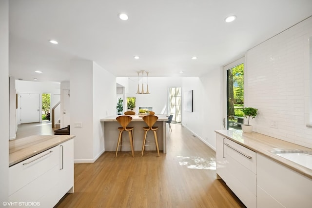 938 Old Green Bay Rd, Winnetka, IL 60093 - kitchen with modern cabinets, white cabinetry, light wood-type flooring, recessed lighting, and light countertops