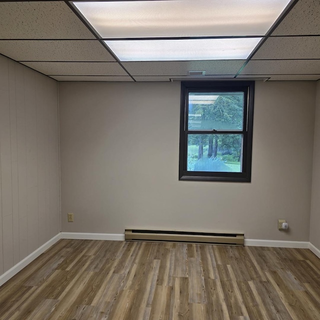 1810 Sylvan Ct, Freeport, IL 61032 - empty room with a drop ceiling, wood finished floors, baseboards, and a baseboard radiator