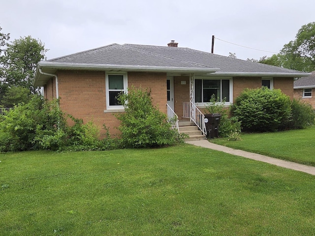 405 W Randolph St, Heyworth, IL 61745 - view of front of home with brick siding, a front yard, a chimney, and a shingled roof