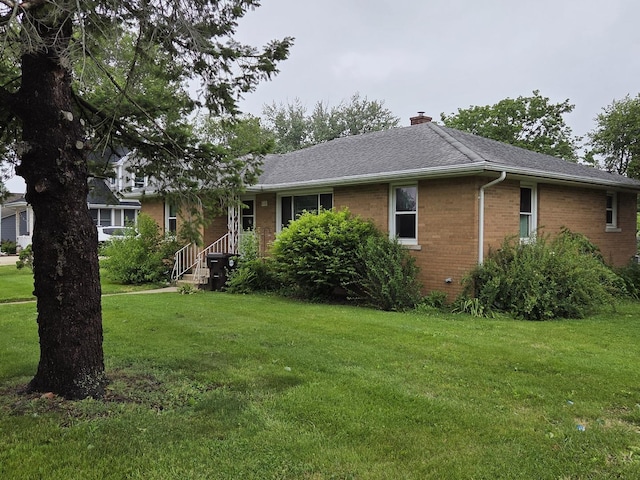 405 W Randolph St, Heyworth, IL 61745 - ranch-style home with brick siding, a front lawn, a chimney, and a shingled roof