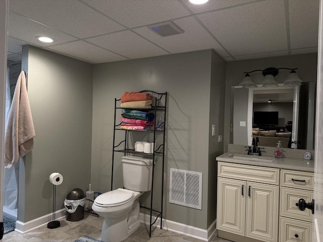 1401 Clement St, Joliet, IL 60435 - bathroom with toilet, baseboards, vanity, a paneled ceiling, and tile patterned flooring