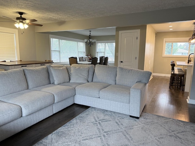 1401 Clement St, Joliet, IL 60435 - living area featuring a chandelier, dark wood-style floors, baseboards, ceiling fan, and a textured ceiling