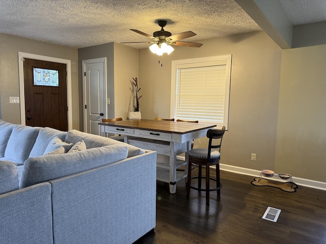 1401 Clement St, Joliet, IL 60435 - living room featuring dark wood-style flooring, baseboards, ceiling fan, and a textured ceiling