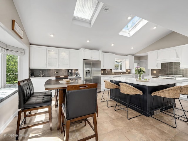 258 S Boyd Ave, Elmhurst, IL 60126 - kitchen with stainless steel refrigerator with ice dispenser, vaulted ceiling, a skylight, a large island, and backsplash