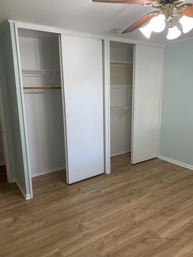 2307 Jay Ln, Rolling Meadows, IL 60008 - unfurnished bedroom with multiple closets, baseboards, and light wood-style floors