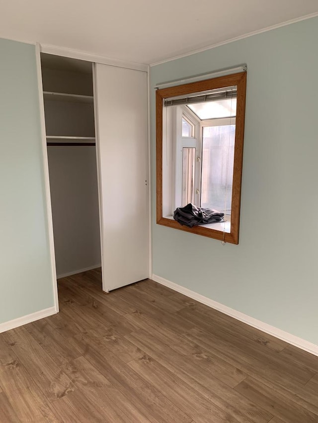 2307 Jay Ln, Rolling Meadows, IL 60008 - unfurnished bedroom featuring wood finished floors, a closet, baseboards, and crown molding