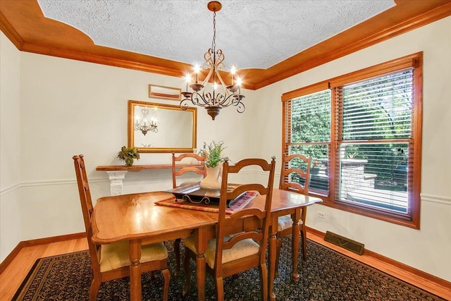 2551 Doncaster Dr, Aurora, IL 60504 - dining space with ornamental molding, a textured ceiling, wood finished floors, plenty of natural light, and a chandelier