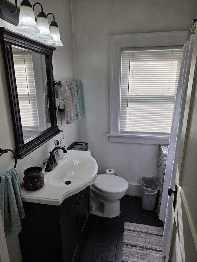 6101/2 W 7th St, Sterling, IL 61081 - bathroom featuring vanity, toilet, healthy amount of natural light, and wood finished floors