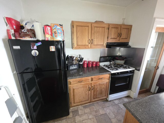 6101/2 W 7th St, Sterling, IL 61081 - kitchen featuring freestanding refrigerator, gas stove, under cabinet range hood, and dark countertops
