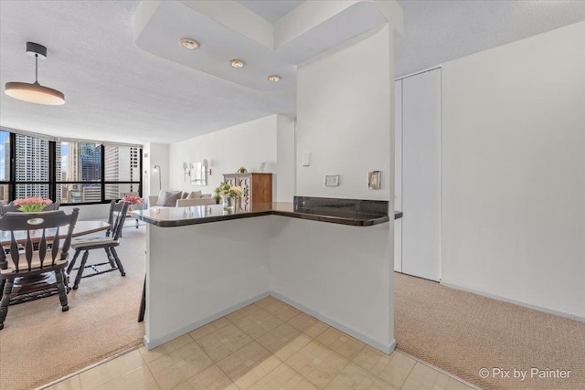 405 N Wabash Ave Unit 2314, Chicago, IL 60611 - kitchen with dark countertops, light colored carpet, open floor plan, a peninsula, and decorative light fixtures