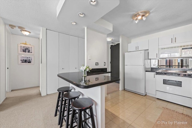 405 N Wabash Ave Unit 2314, Chicago, IL 60611 - kitchen with white appliances, a kitchen bar, dark countertops, white cabinets, and a textured ceiling