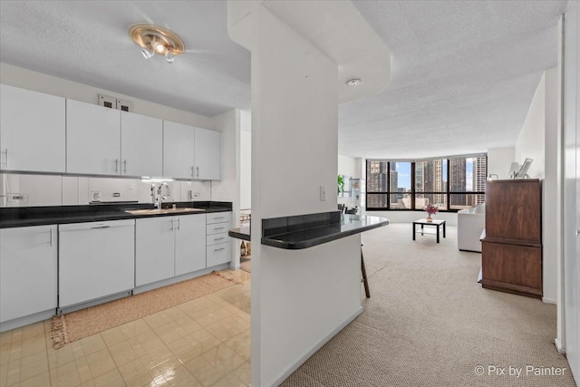 405 N Wabash Ave Unit 2314, Chicago, IL 60611 - kitchen with a sink, open floor plan, dark countertops, a textured ceiling, and white cabinets