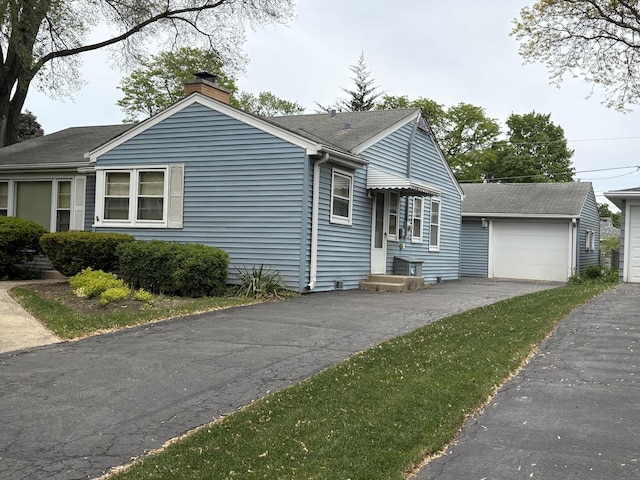 159 S Brockway St, Palatine, IL 60067 - view of front facade with a chimney, an outdoor structure, a garage, and a shingled roof