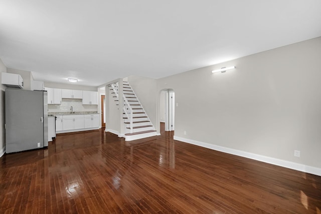 402 Miami St, Joliet, IL 60432 - unfurnished living room featuring a sink, baseboards, dark wood-style flooring, and stairway