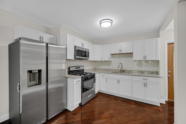 402 Miami St, Joliet, IL 60432 - kitchen featuring appliances with stainless steel finishes, a sink, light stone counters, dark wood finished floors, and white cabinetry