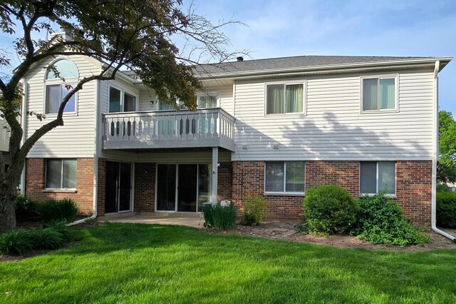 1338 Stratford Dr Unit 1338, Gurnee, IL 60031 - rear view of house with brick siding, a balcony, and a lawn