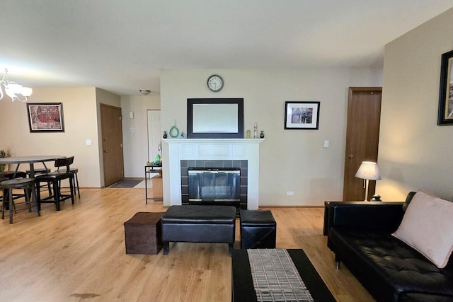 1338 Stratford Dr Unit 1338, Gurnee, IL 60031 - living area with light wood-style floors, a chandelier, a tiled fireplace, and baseboards