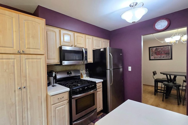 1338 Stratford Dr Unit 1338, Gurnee, IL 60031 - kitchen with appliances with stainless steel finishes, light brown cabinetry, light countertops, decorative backsplash, and a chandelier