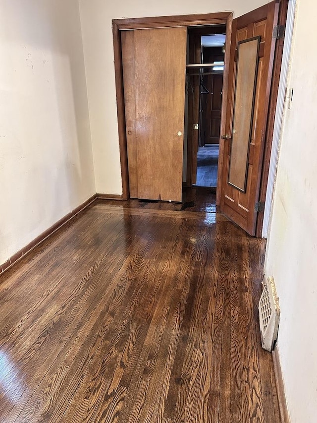 301 W 104th St, Chicago, IL 60628 - unfurnished bedroom featuring dark wood-style floors, baseboards, and a closet