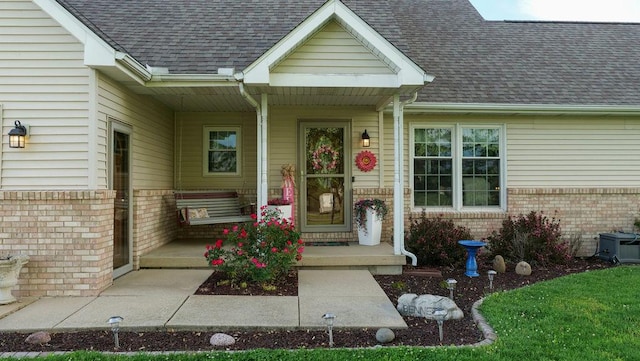 29 N Deer Lk N, Villa Grove, IL 61956 - doorway to property featuring brick siding, covered porch, and a shingled roof