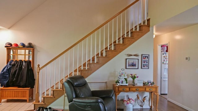 29 N Deer Lk N, Villa Grove, IL 61956 - staircase featuring a towering ceiling, wood finished floors, and baseboards