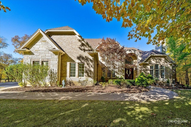 53 Abbeyfeale Dr, Oswego, IL 60543 - french country inspired facade with stone siding, a front lawn, and brick siding