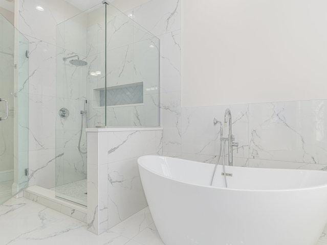 223 Center St, Naperville, IL 60540 - full bathroom featuring marble tiled flooring, tile walls, a marble finish shower, a freestanding tub, and a wainscoted wall