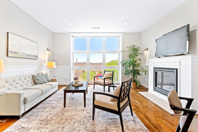 2431 W Belmont Ave Unit 3E, Chicago, IL 60618 - living room featuring wood finished floors, healthy amount of natural light, a wainscoted wall, a fireplace with flush hearth, and recessed lighting