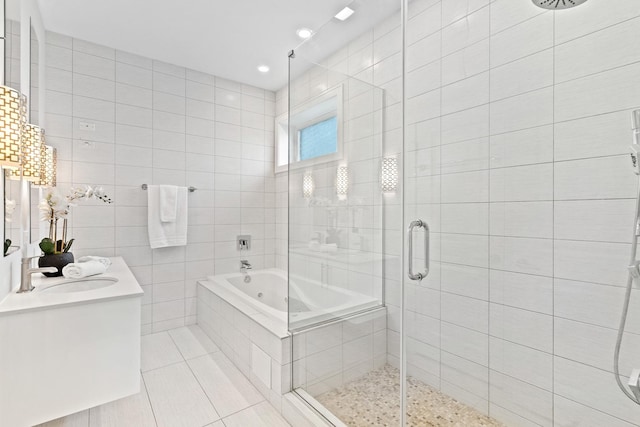 2431 W Belmont Ave Unit 3E, Chicago, IL 60618 - bathroom with a stall shower, tile patterned floors, double vanity, a garden tub, and tile walls