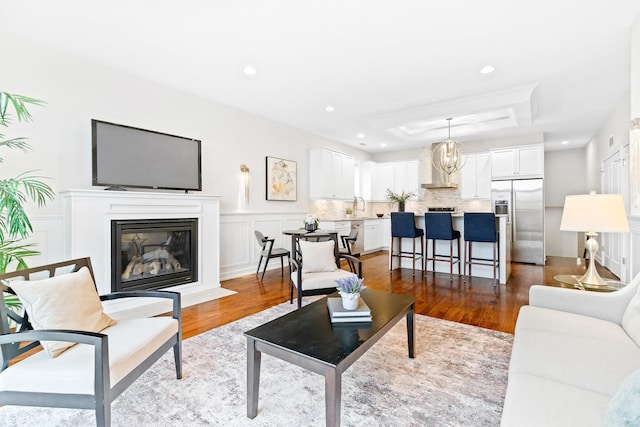 2431 W Belmont Ave Unit 3E, Chicago, IL 60618 - living room with wood finished floors, a glass covered fireplace, recessed lighting, a tray ceiling, and a decorative wall