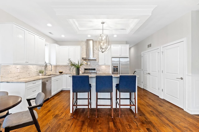 2431 W Belmont Ave Unit 3E, Chicago, IL 60618 - kitchen with stainless steel appliances, wall chimney exhaust hood, a raised ceiling, a center island, and dark wood-style flooring