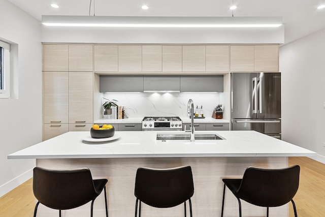 4906 N Kenmore Ave Unit 2S, Chicago, IL 60640 - kitchen with a sink, freestanding refrigerator, modern cabinets, decorative backsplash, and a kitchen breakfast bar