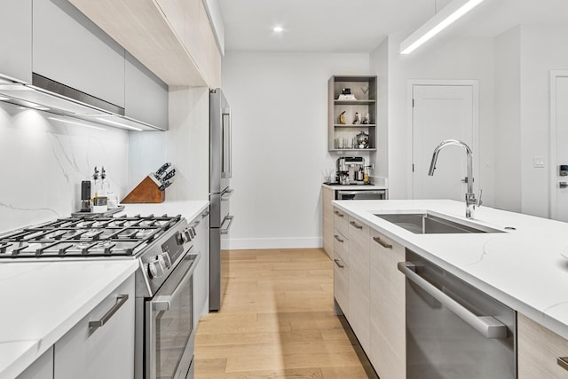 4906 N Kenmore Ave Unit 2S, Chicago, IL 60640 - kitchen with appliances with stainless steel finishes, a sink, modern cabinets, light wood finished floors, and range hood