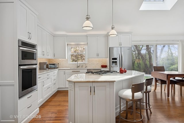 22585 N Ruth Ct, Kildeer, IL 60047 - kitchen with appliances with stainless steel finishes, healthy amount of natural light, a skylight, and a center island