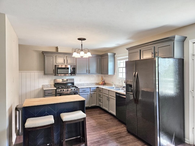 1409 Hull St, Normal, IL 61761 - kitchen with appliances with stainless steel finishes, a sink, gray cabinets, wainscoting, and decorative light fixtures
