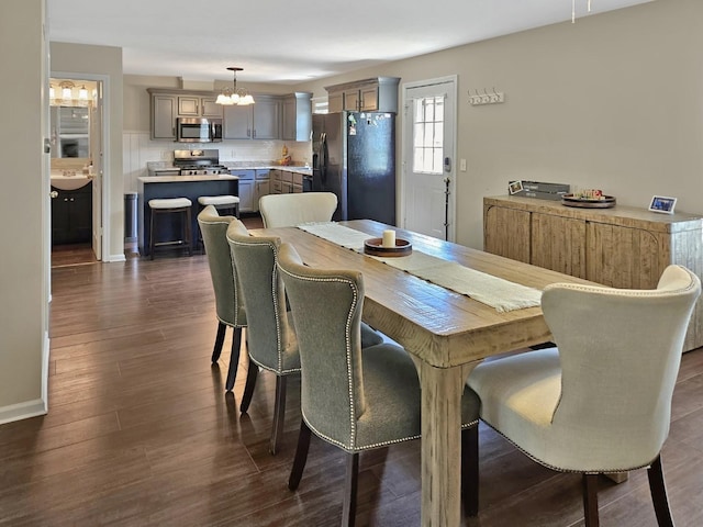 1409 Hull St, Normal, IL 61761 - dining area with a chandelier, dark wood-style floors, and baseboards