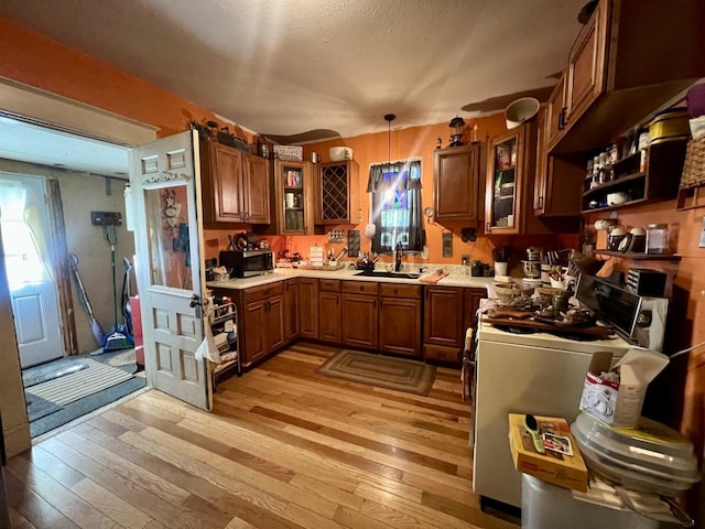 207 W 2nd St, Broadlands, IL 61816 - kitchen featuring stainless steel microwave, stove, light wood-style floors, light countertops, and brown cabinets